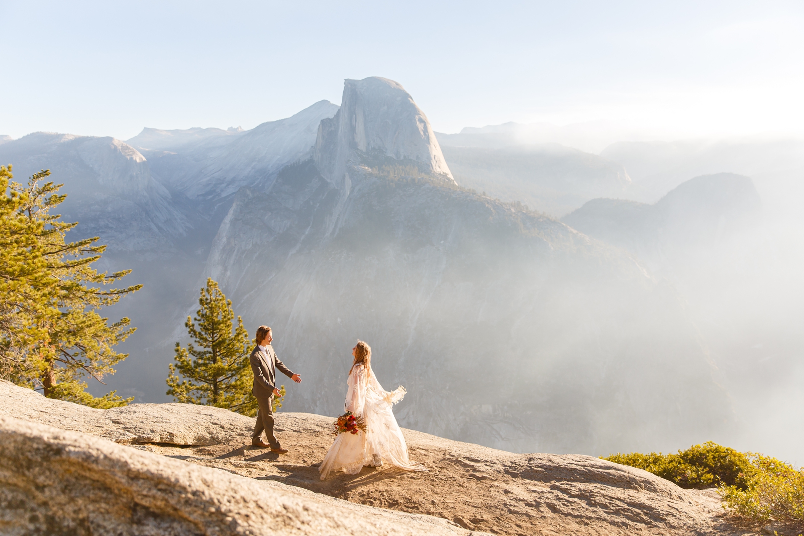 A bride and groom walk towards each other in Yosemite.