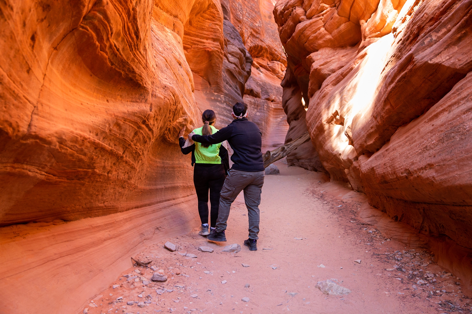 A guy grabbing his almost fiancé to move her to the middle of the slot canyon to propose to her