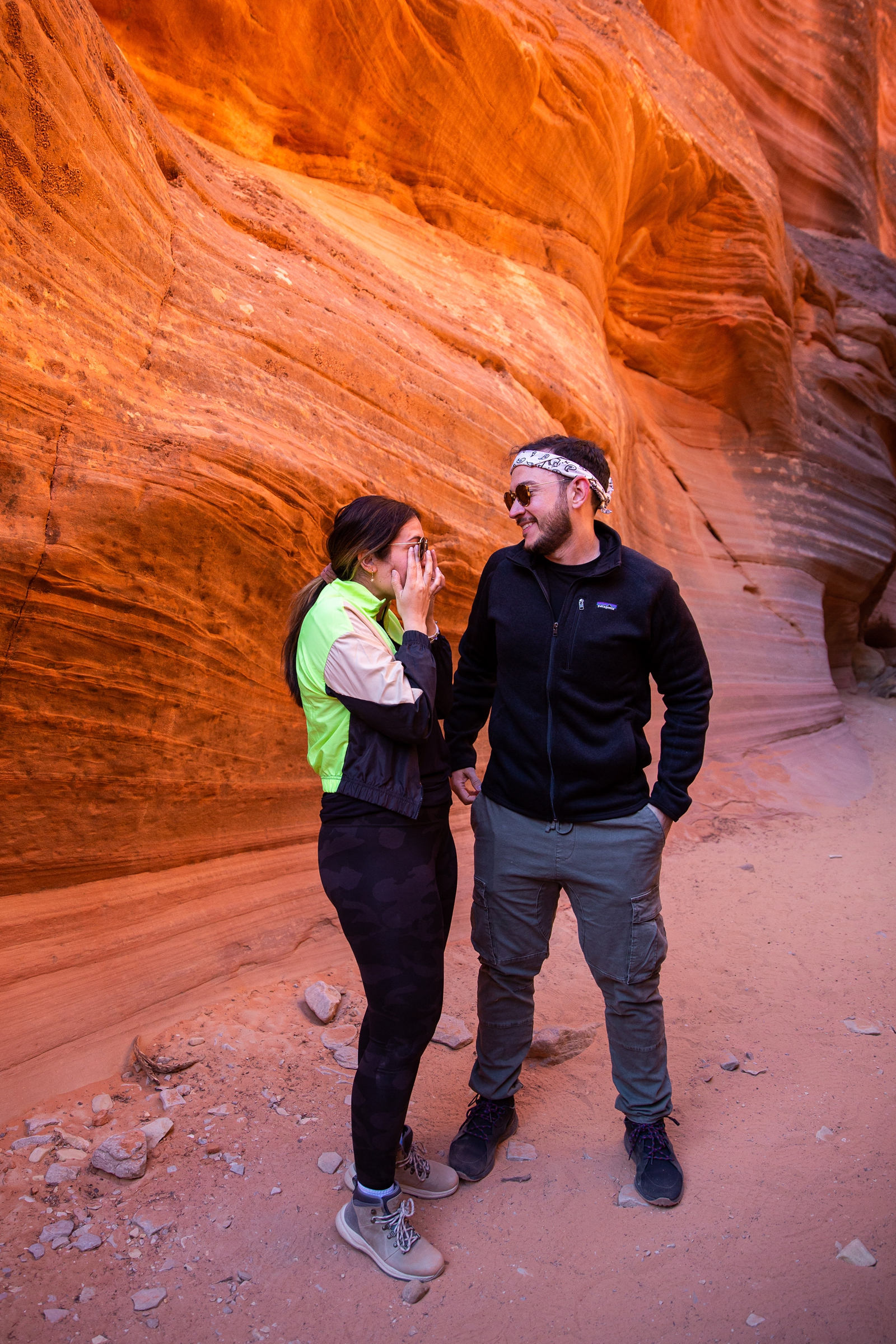 A newly engaged couple joyfully wiping tears away and looking so happy in the Utah slot canyon