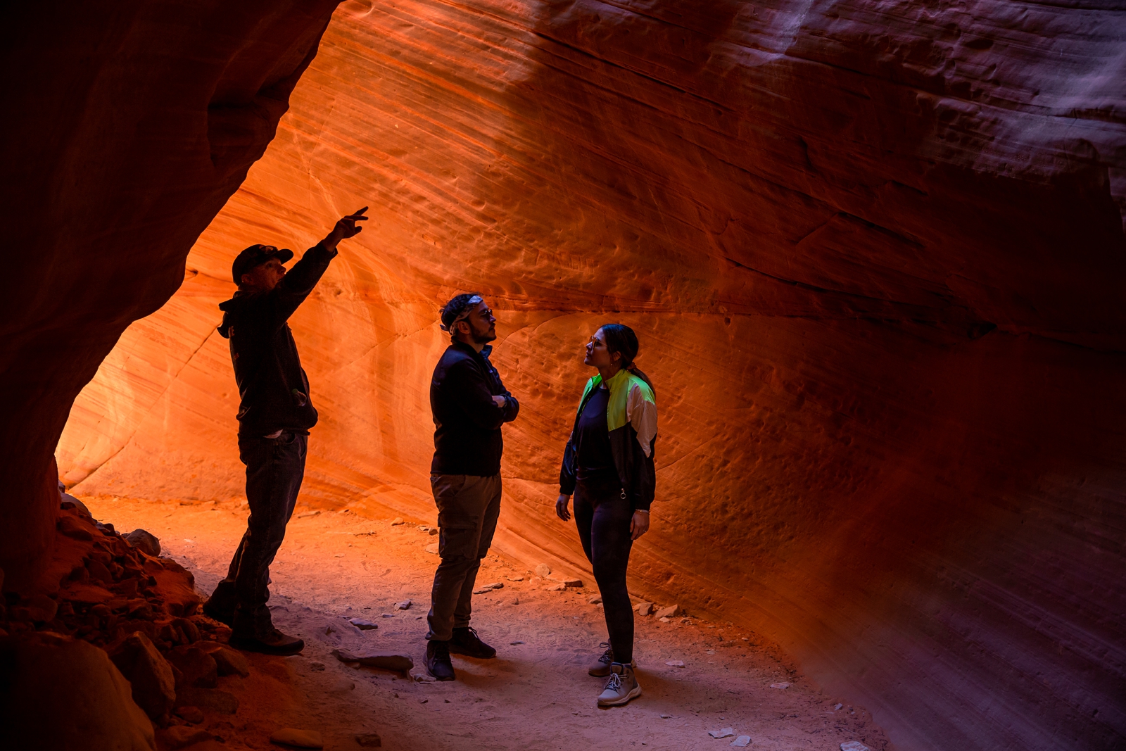 A Couple and their tour guide walking through the Utah slot canyon during their hiking adventure through the antelope canyon