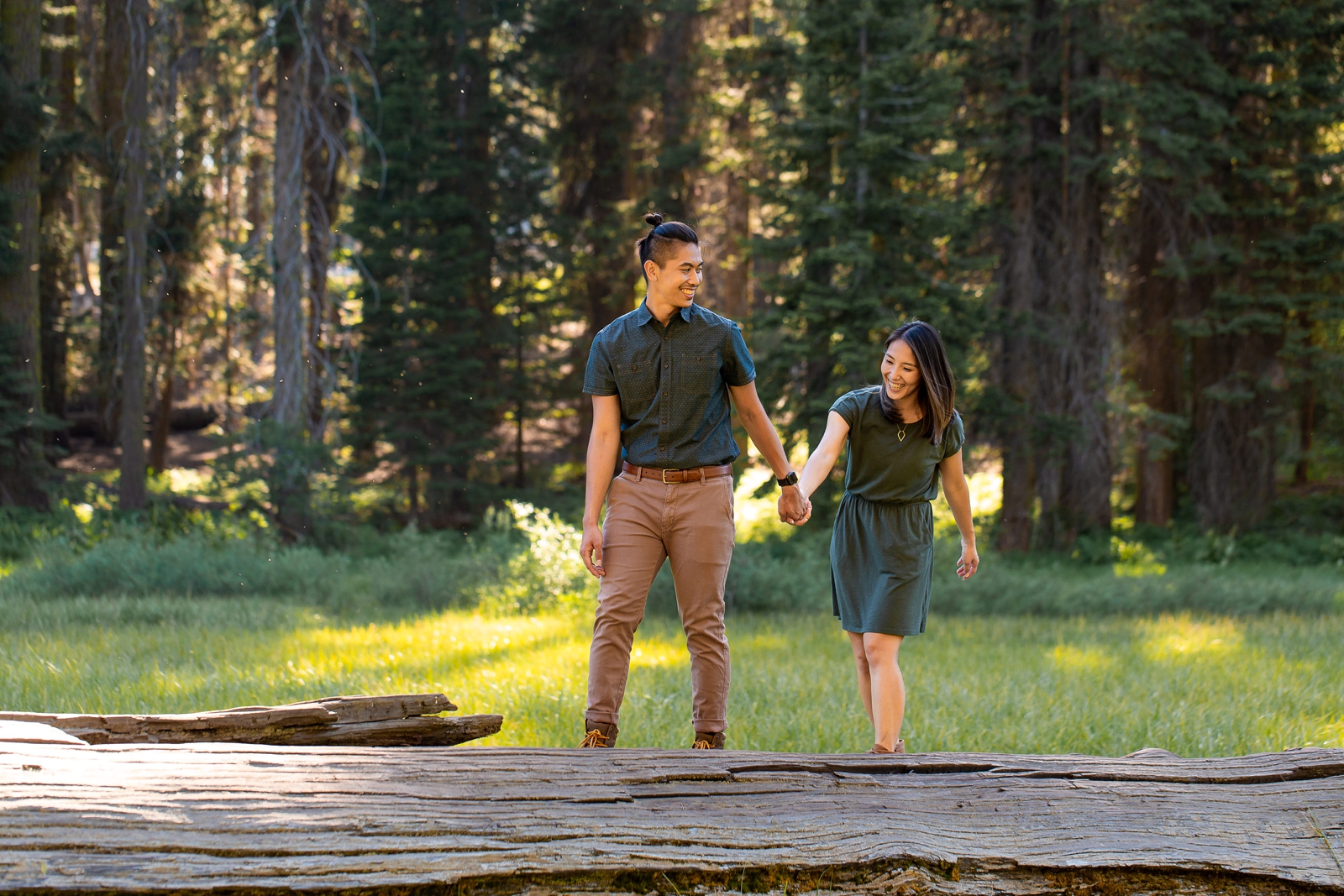Couple hiking along a fallen tree in Sequoia National Park.