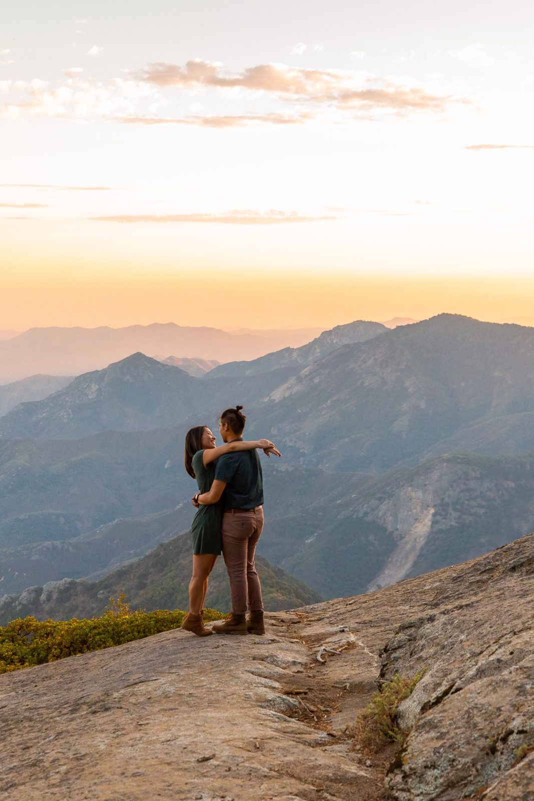 Embracing engaged couple on a cliff in Sequoia, CA