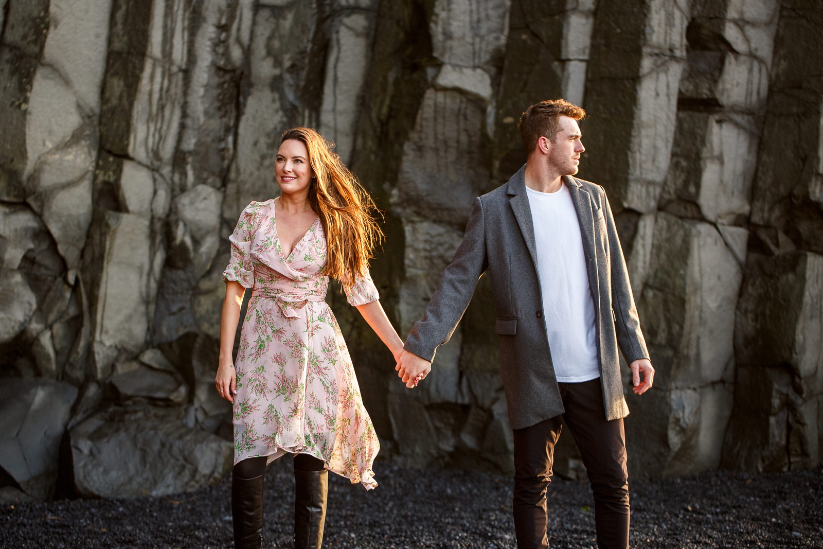 Engaged Couple holding hands by the basalt columns at their destination Iceland engagement session near Vik, Iceland
