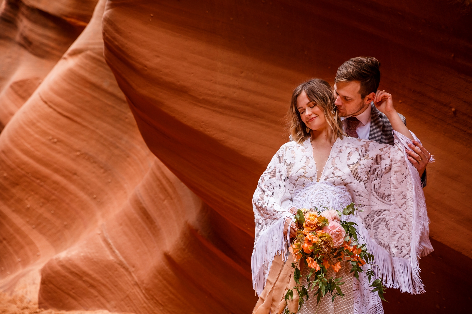 A beautiful in-love couple embracing and smiling at each other during their adventurous slot canyon elopement in Waterholes Canyon near Lake Powell in Page Arizona