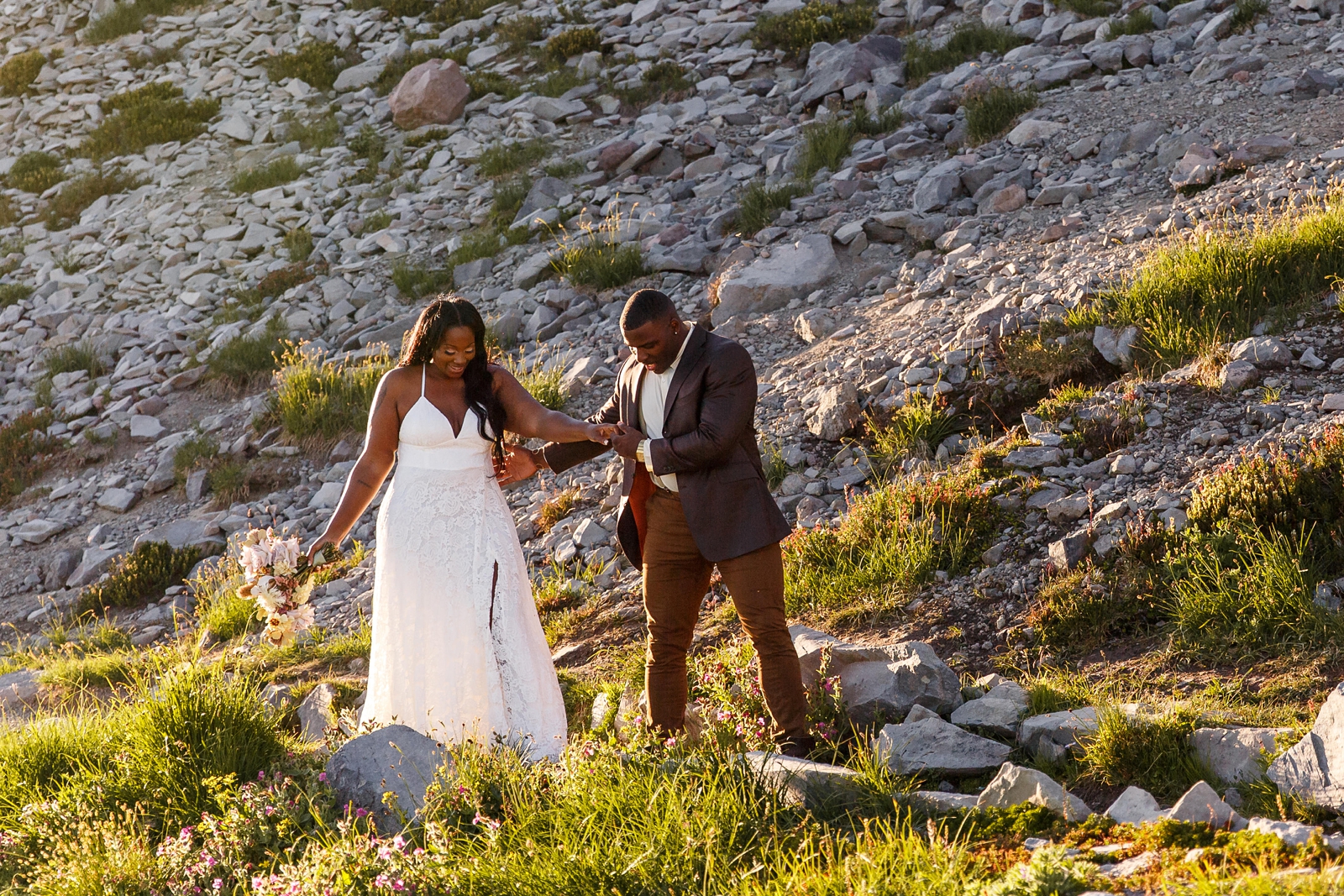 These partners navigate a rugged path at Mount Rainier National Park during their Mount Rainier hiking elopement. 