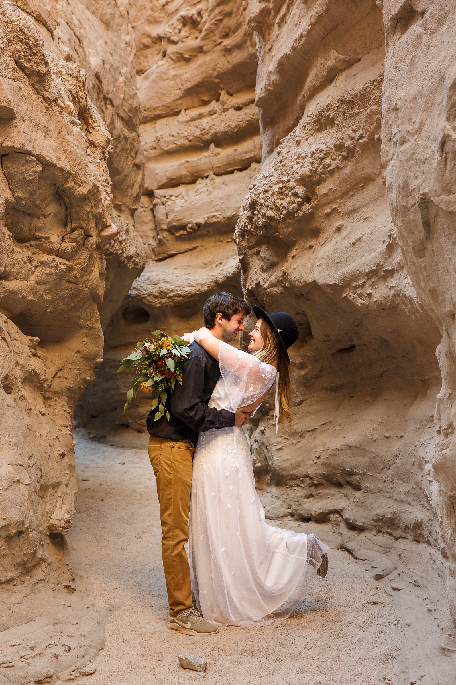 This couple embrace during their outdoor elopement at this slot canyon.