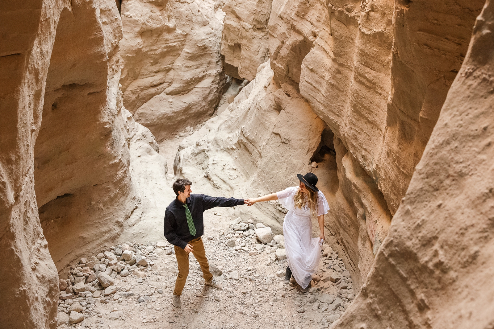 At this California slot canyon elopement, this bride and groom squeezed through narrow sandstone canyons and used ropes to climb the canyon.