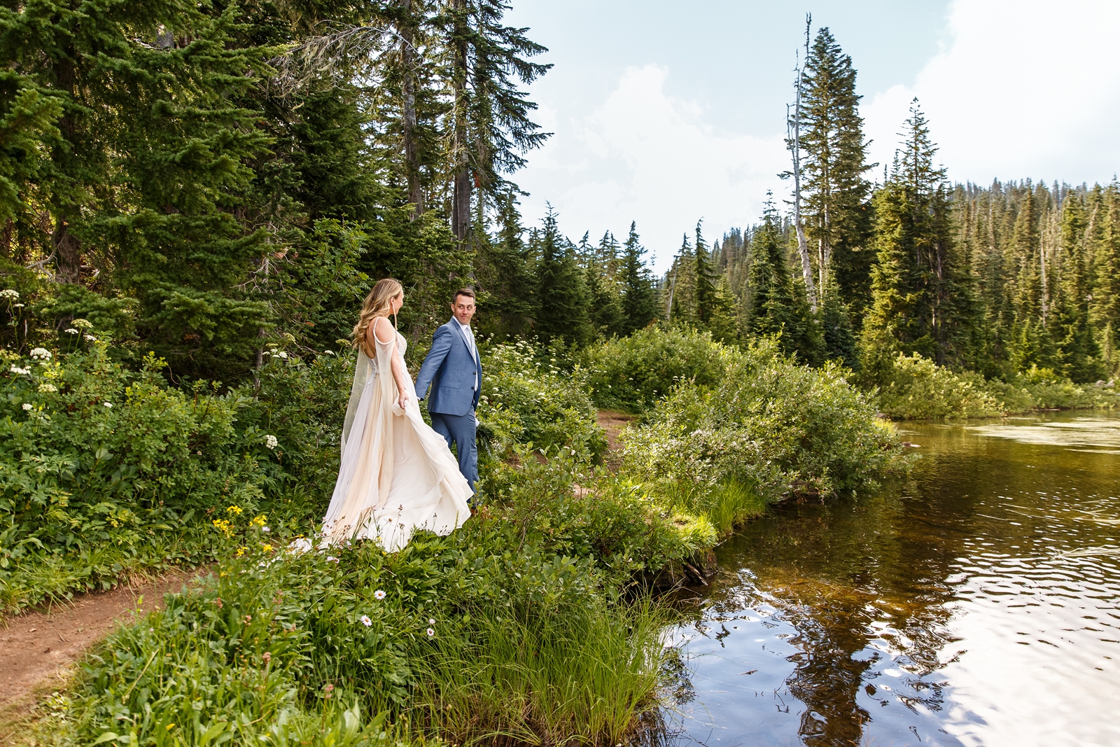 A happy couple hike beside Reflection Lakes during their Mount Rainier elopement.