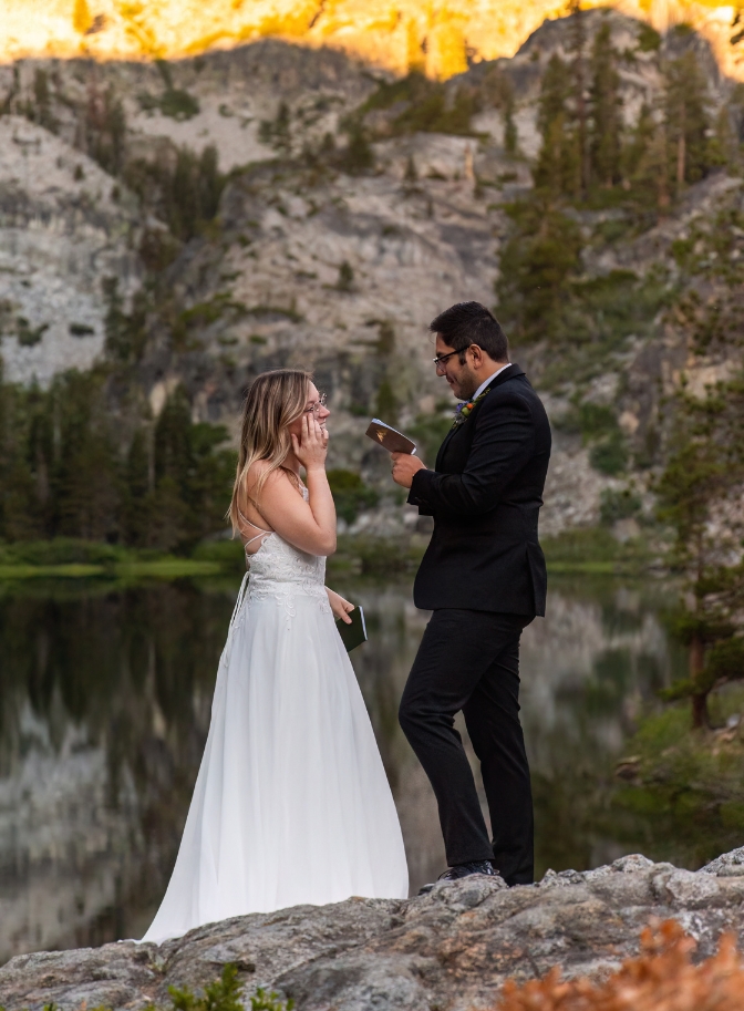 photo of bride wiping away tears as groom reads his vows at their Lake Tahoe wedding