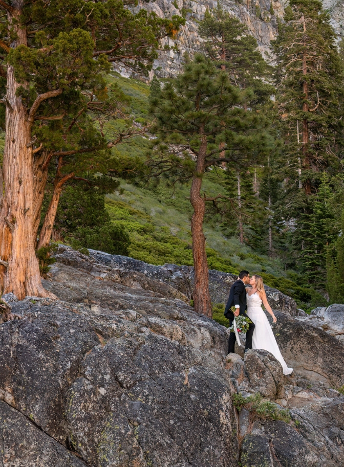 photo of bride and groom kissing on their wedding day on rock face