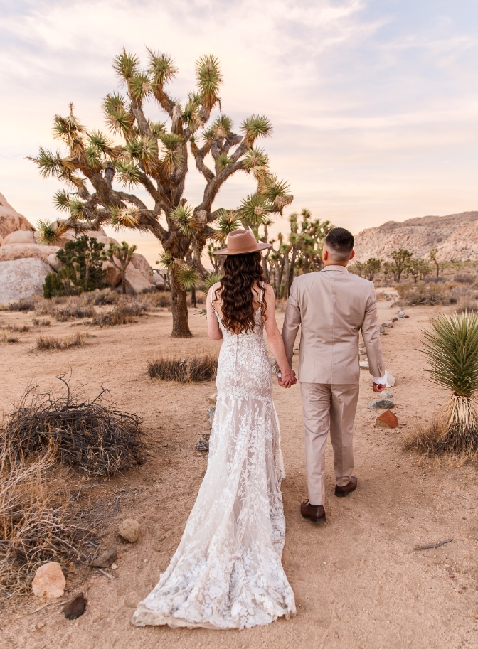 bride and groom holding hands and walking around Joshua Tree National Park