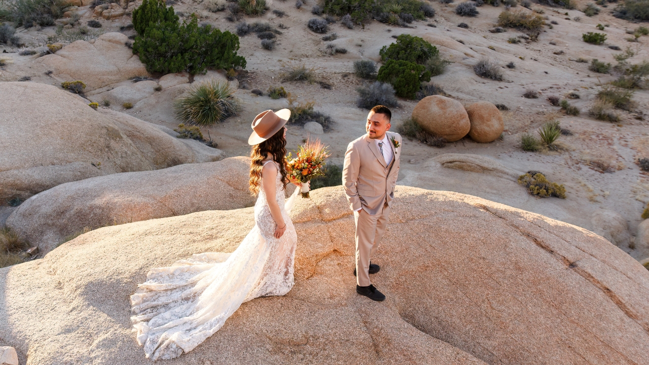 photo of groom looking back and his bride on a rock face