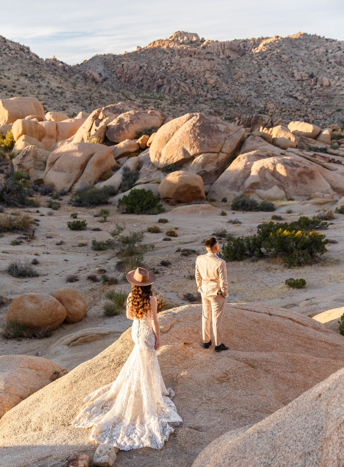 Photo of bride walking towards groom on rocky surface