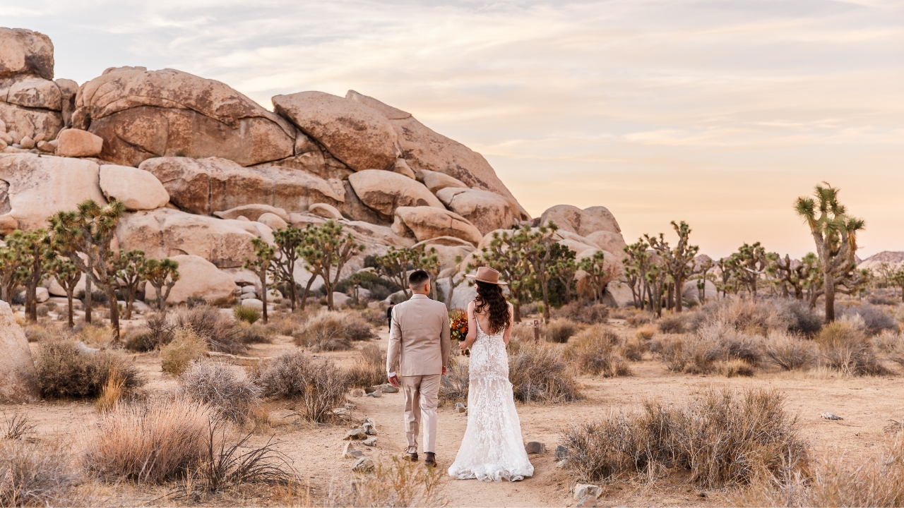 photo of bride and groom walking towards rocks for their Joshua Tree wedding