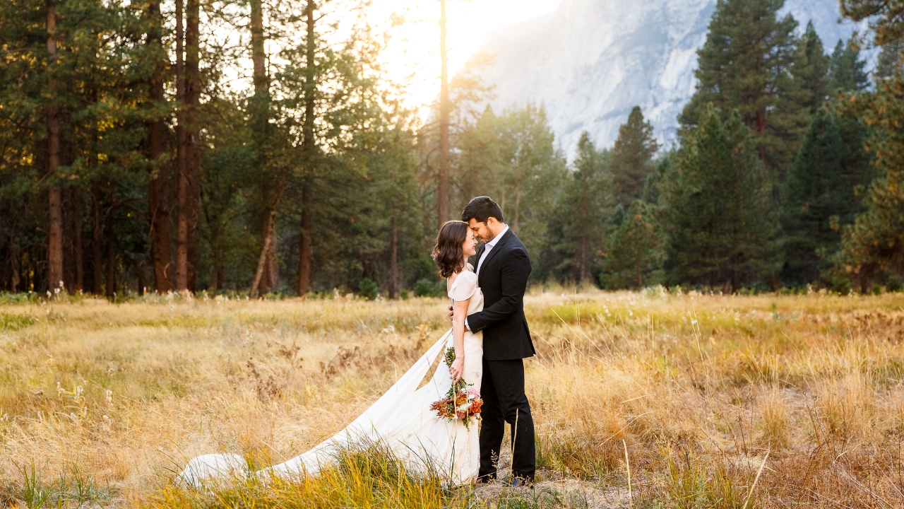 photo of bride and groom with foreheads touching in a meadow at Yosemite for their elopement