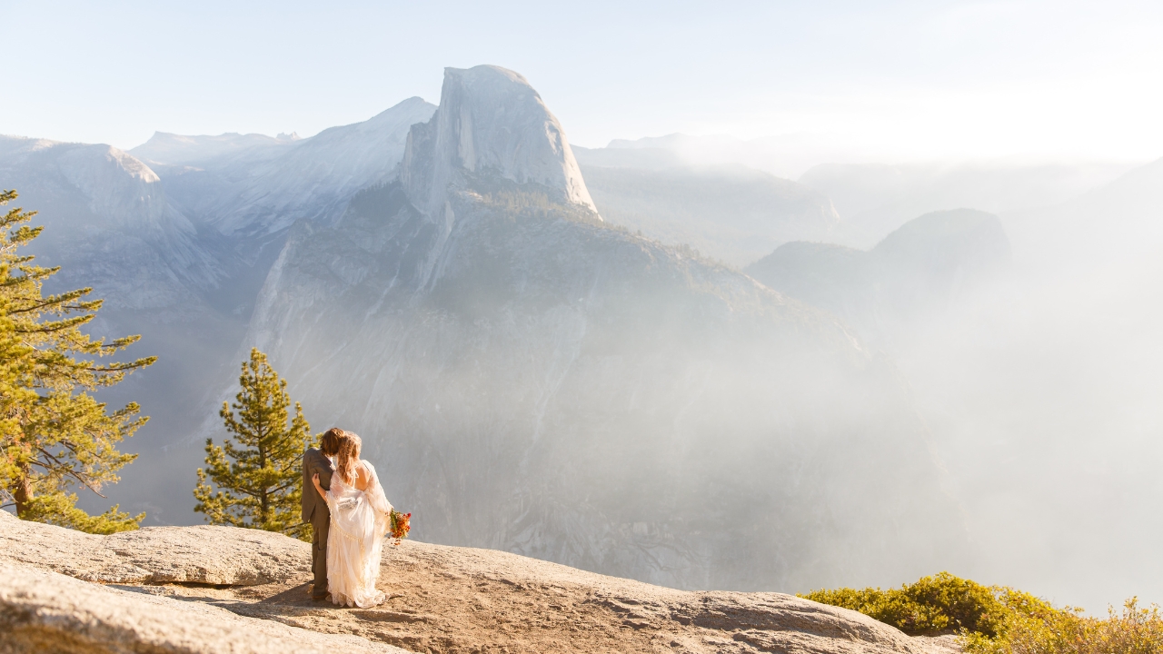 photo of bride and groom looking out at Sierra Mountain Range in Yosemite for elopement