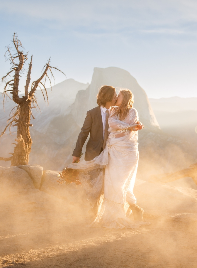 photo of bride and groom embracing with Half Dome behind them