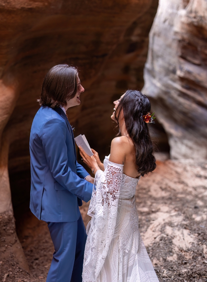 bride and groom laughing as they exchange vows in a slot canyon in Zion National Park