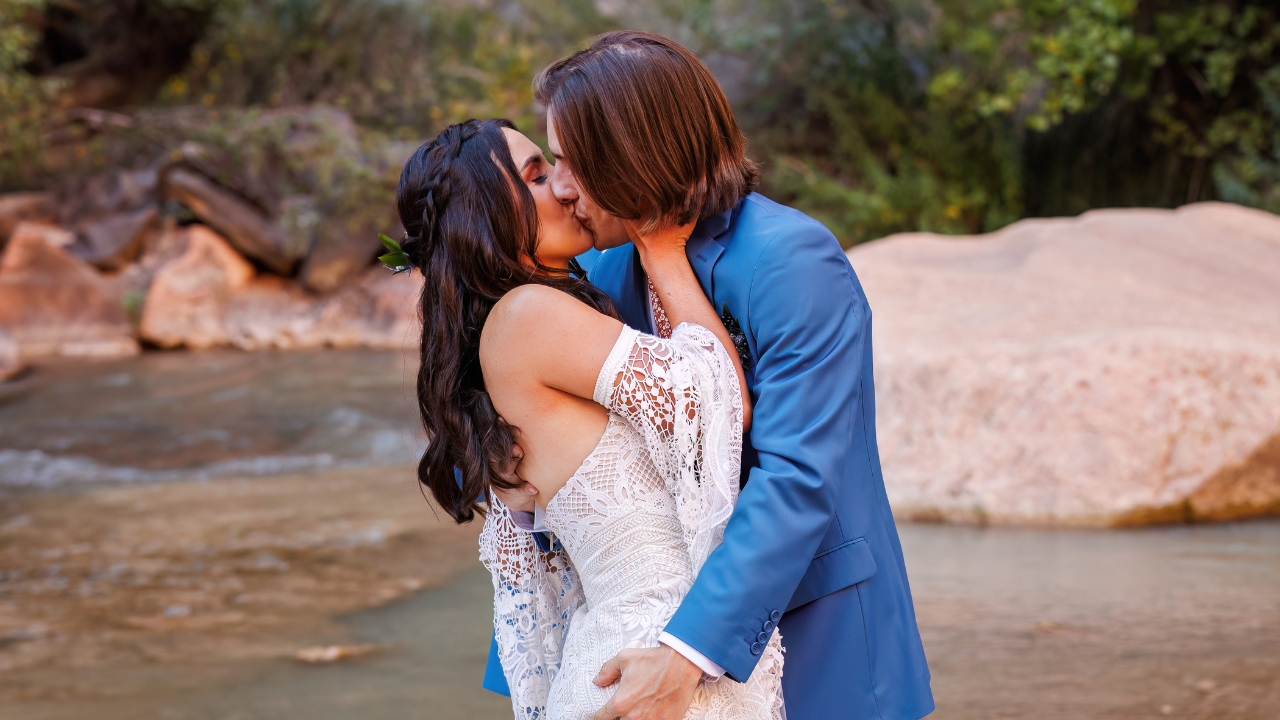 photo of bride and groom kissing with river behind them at their Zion National Park elopement