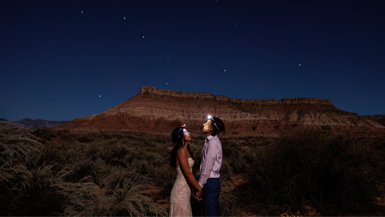photo of bride and groom wearing headlamps looking up at the stars in Zion National Park