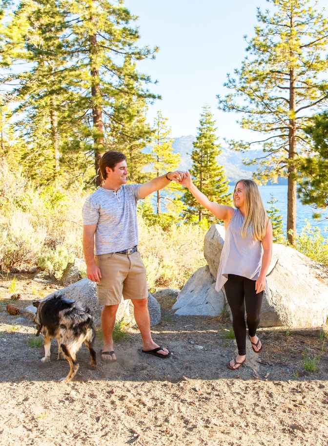 photo of man spinning woman around with dog beside them