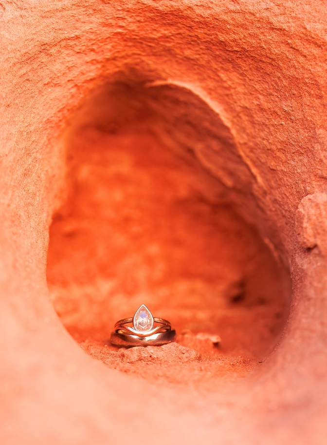 photo of tear drop engagement ring surrounded by red rock