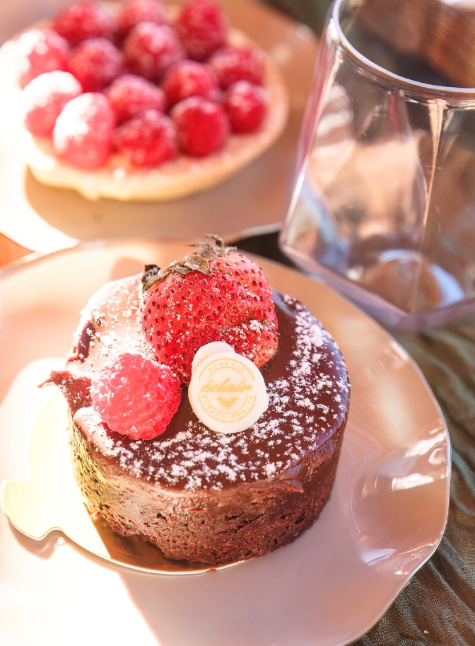 photo of chocolate cake and strawberries on a picnic table