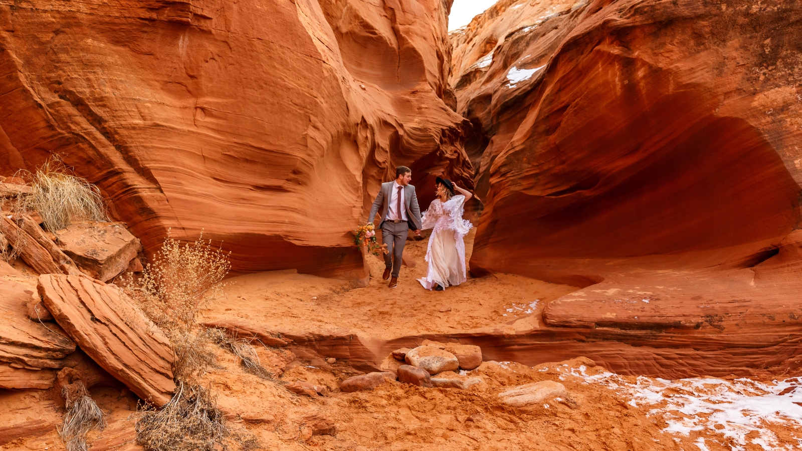 photo of bride and groom walking through slot canyon for elopement