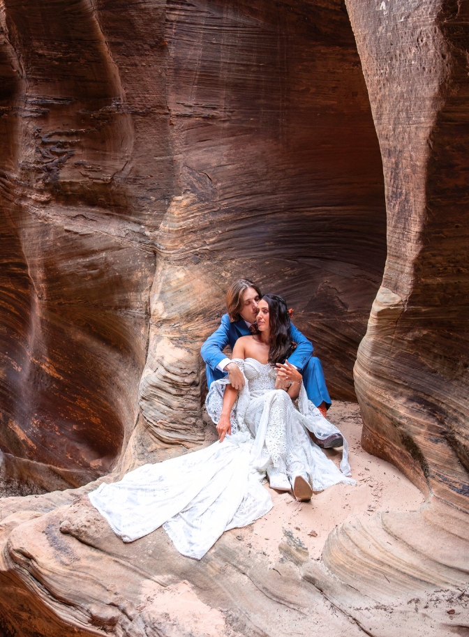 photo of bride and groom cuddling inside a slot canyon in Zion National Park