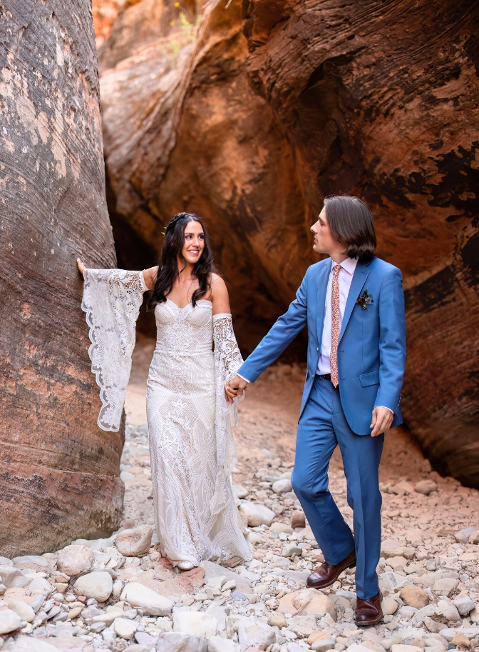 photo of bride and groom walking through slot canyon in Zion National Park 