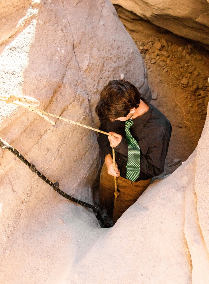 photo of groom rappelling down slot canyon for elopement