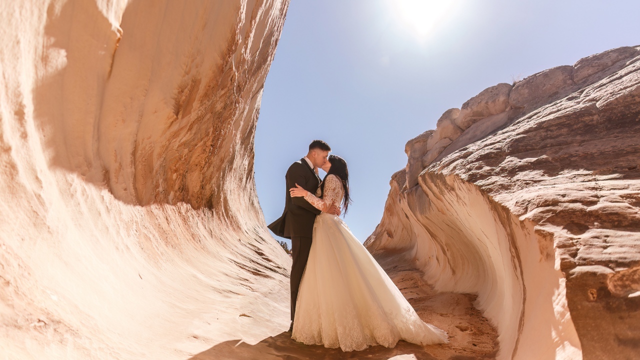 photo of bride and groom kiss at the entrance of a slot canyon outside of Horseshoe Bend