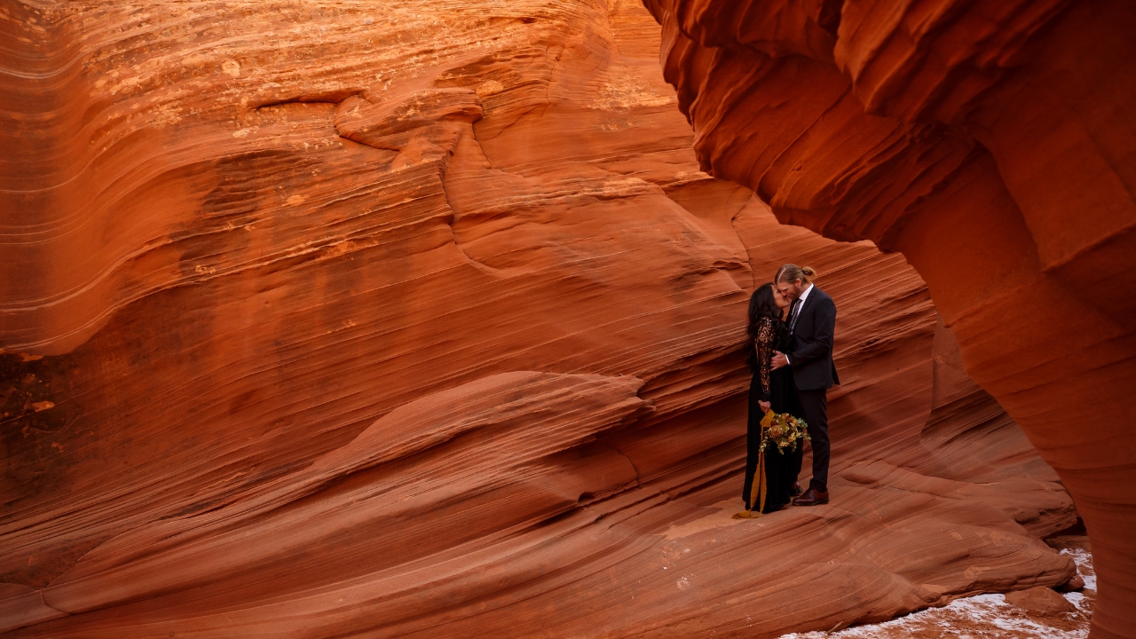 photo of bride and groom kissing on the ledge of a rockface for their slot canyon elopement