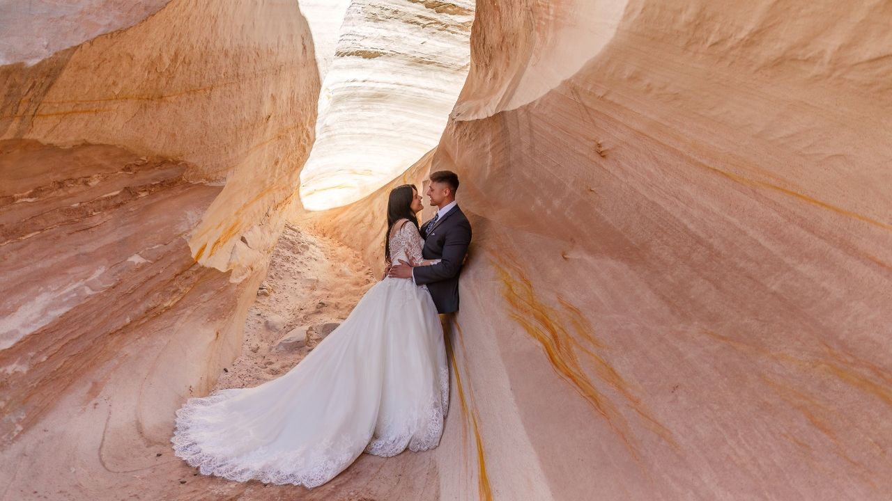 photo of bride and groom embracing along the wall of a slot canyon near Horseshoe Bend