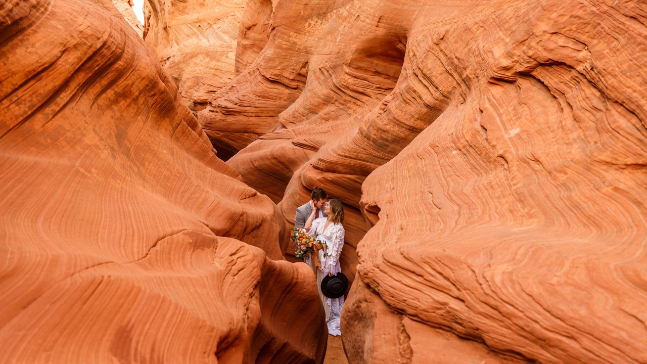 photo of bride and groom forehead to forehead standing in the middle of a slot canyon for their elopement