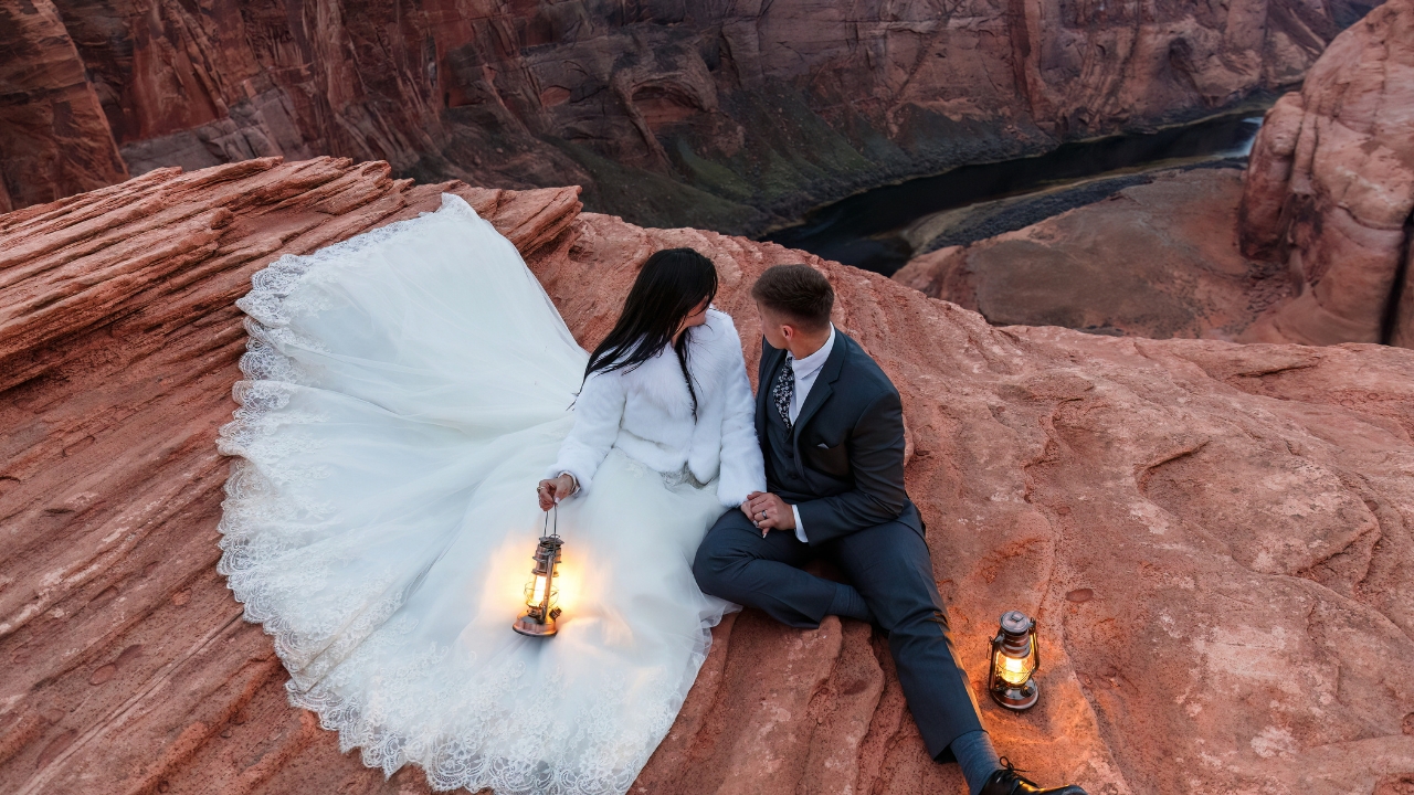 photo of bride and groom holding hands at twilight with the Colorado River behind them