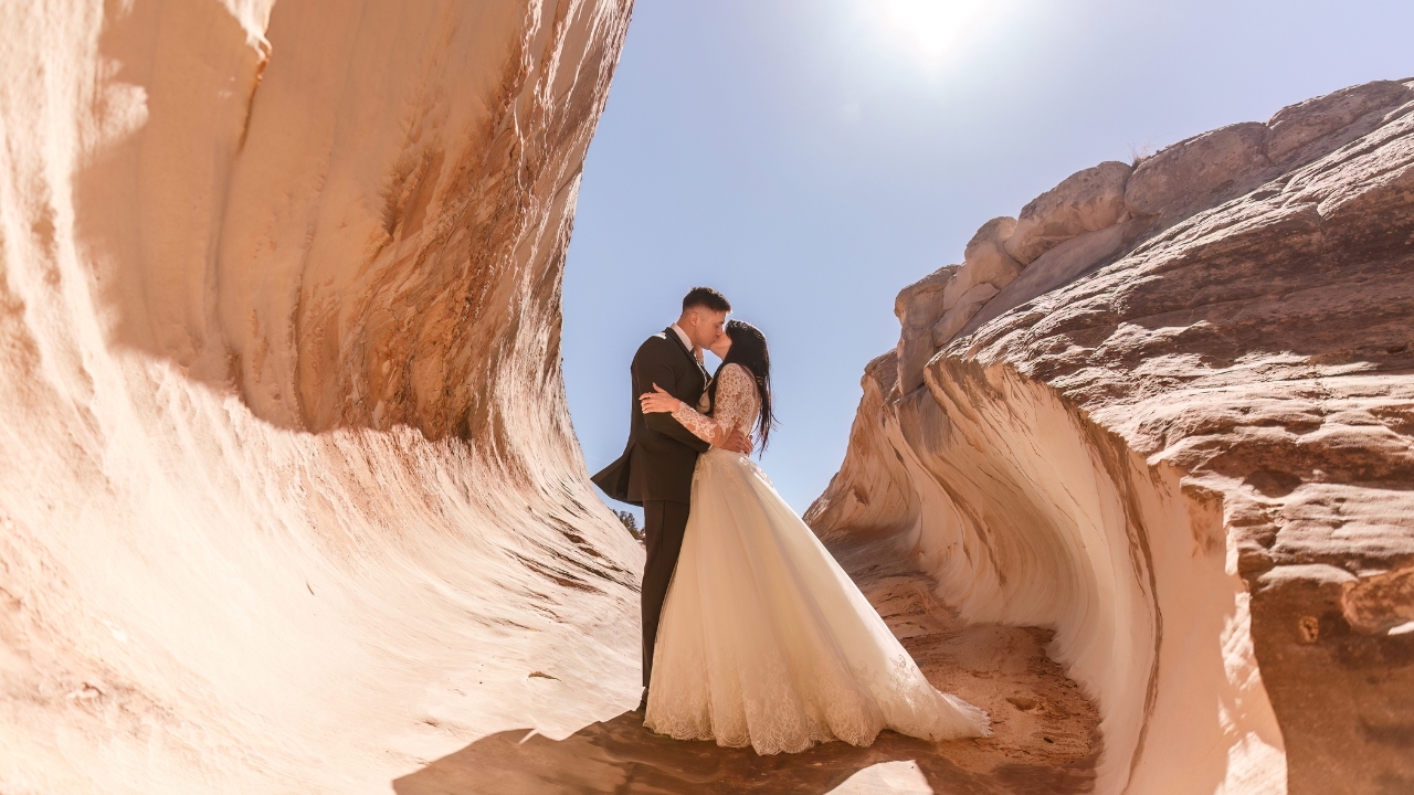 photo of bride and groom kissing between tan rock faces