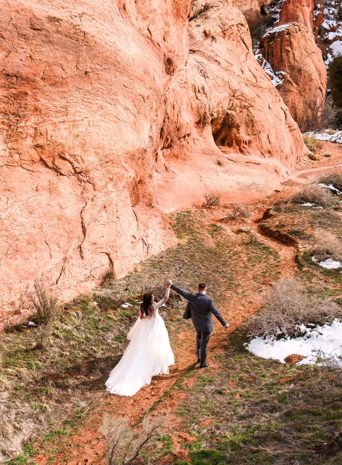 photo of bride and groom holding hands up in the air celebrating