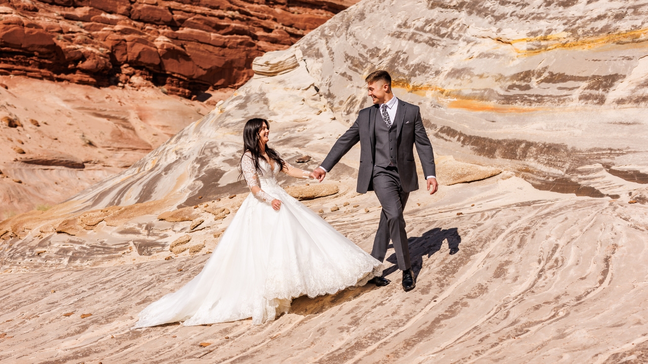 photo of bride and groom hiking through white rock sandstone