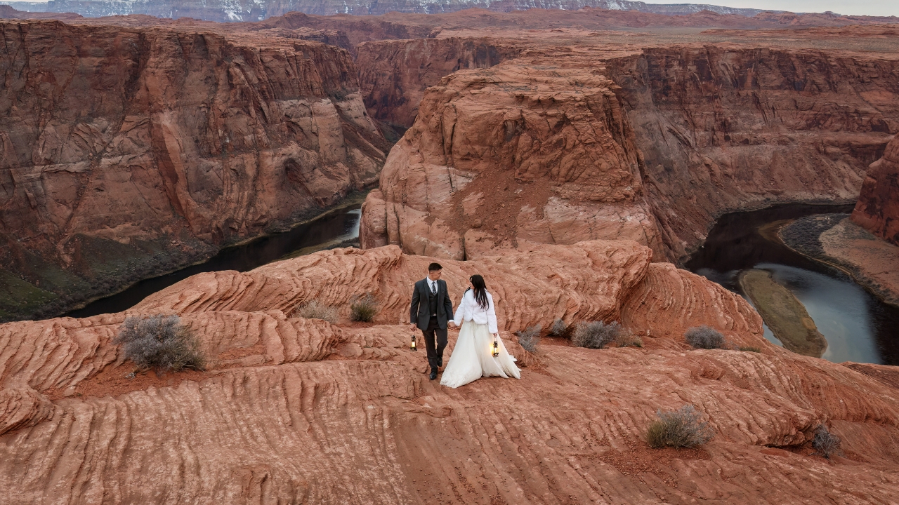 photo of bride and groom holding hands and carrying lanterns on their wedding day at Horseshoe Bend