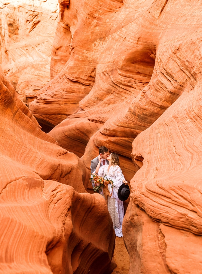 photo of bride and groom kissing at Waterhole Canyon on their wedding day