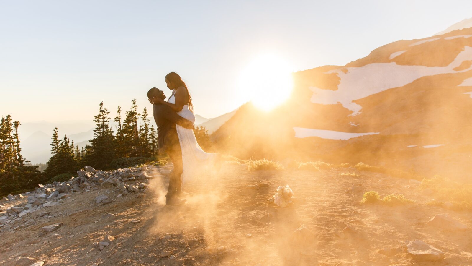 photo of groom lifting bride at sunset on mountain in Mt Rainier National Park