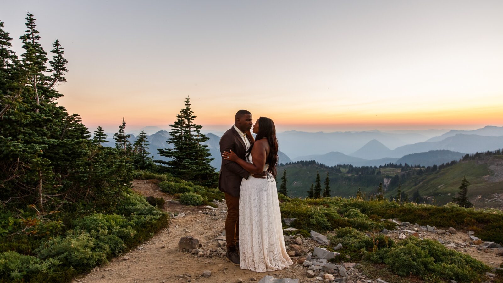 photo of bride and groom embracing and staring into each others eyes at sunset with Mount Rainier mountain range behind them