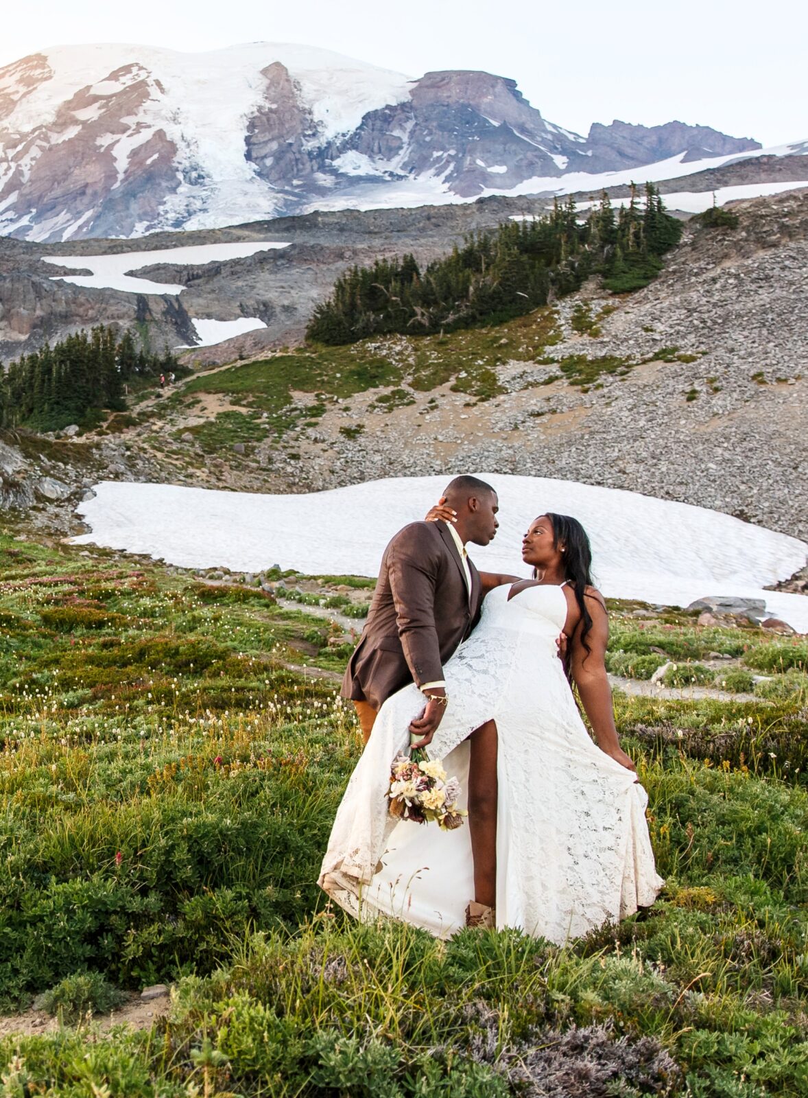 photo of groom dipping bride with mountain behind them