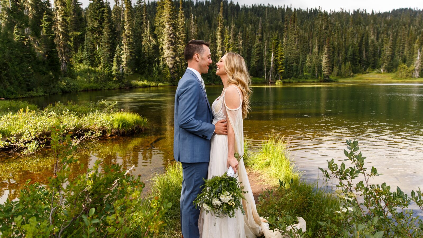 photo of groom holding bride and staring at her in front of Reflection Lakes for wedding day