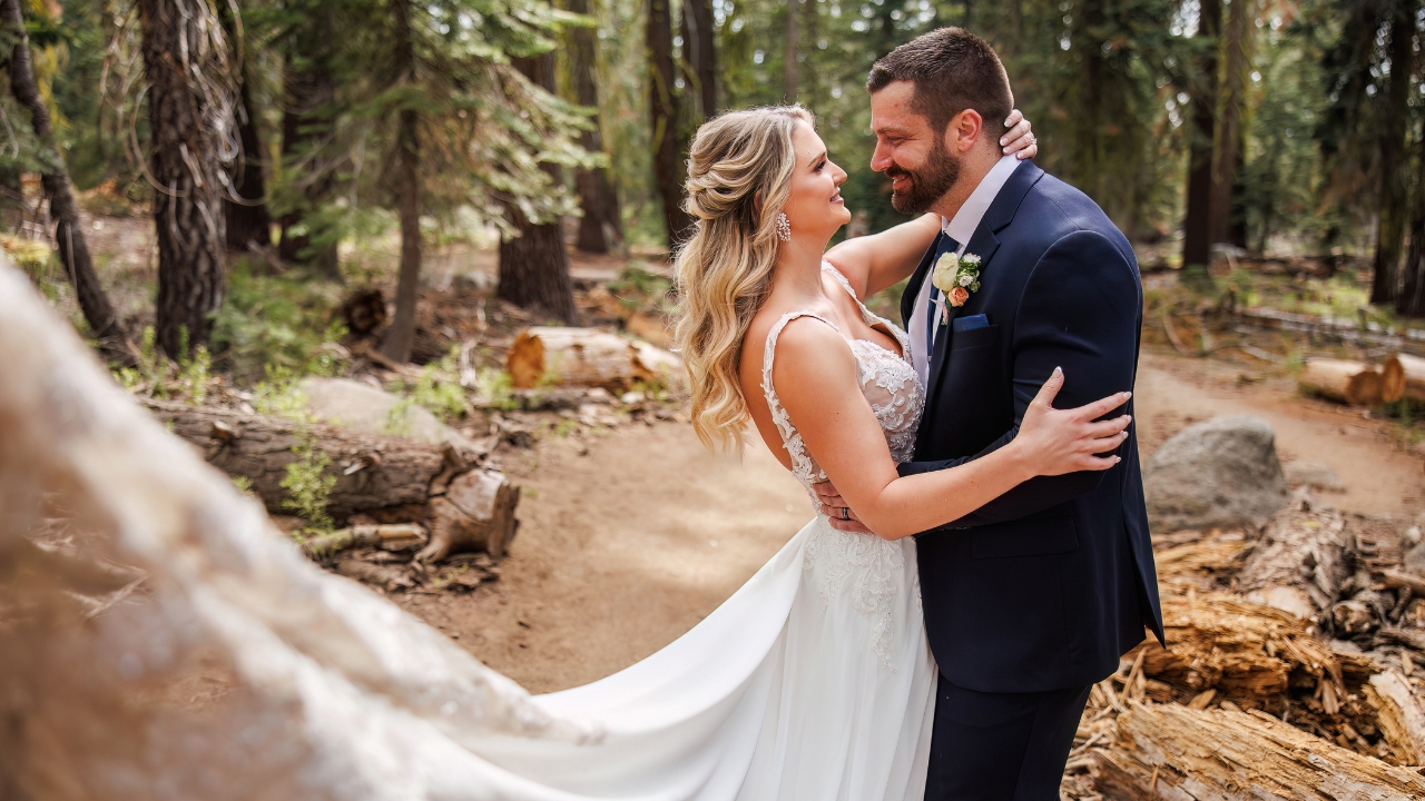 photo of bride and groom staring into each others eyes in the woods with veil flowing behind her