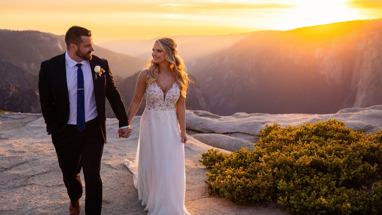 photo of bride and groom holding hands at Taft Point with sun setting behind them