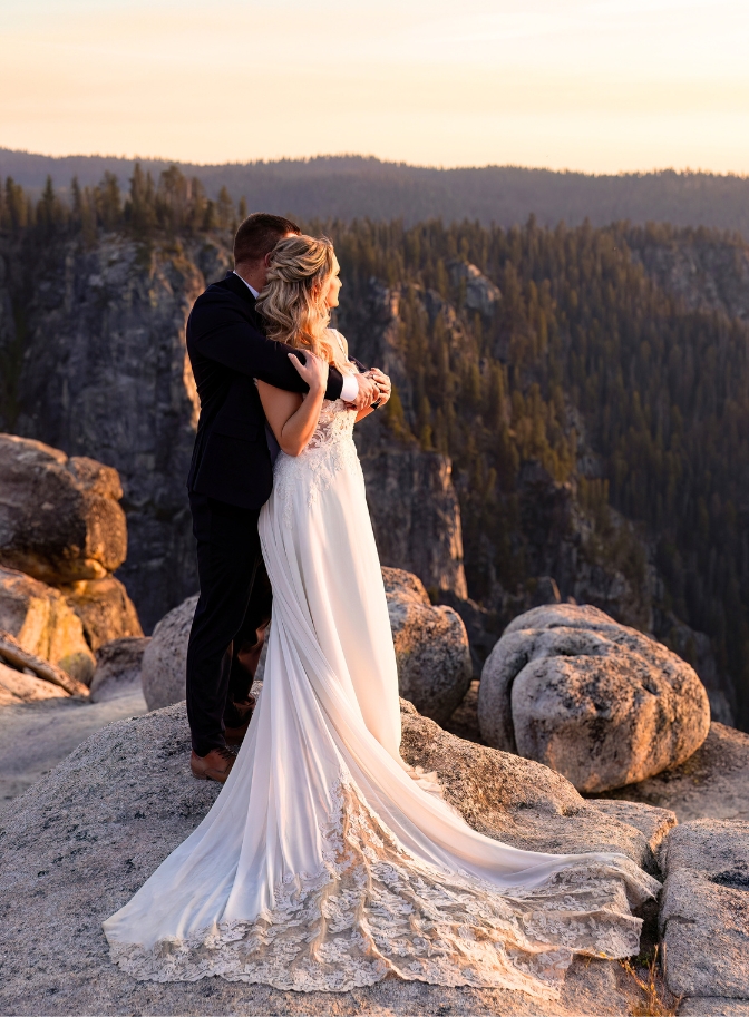 photo of bride and groom watching the sunset while embracing