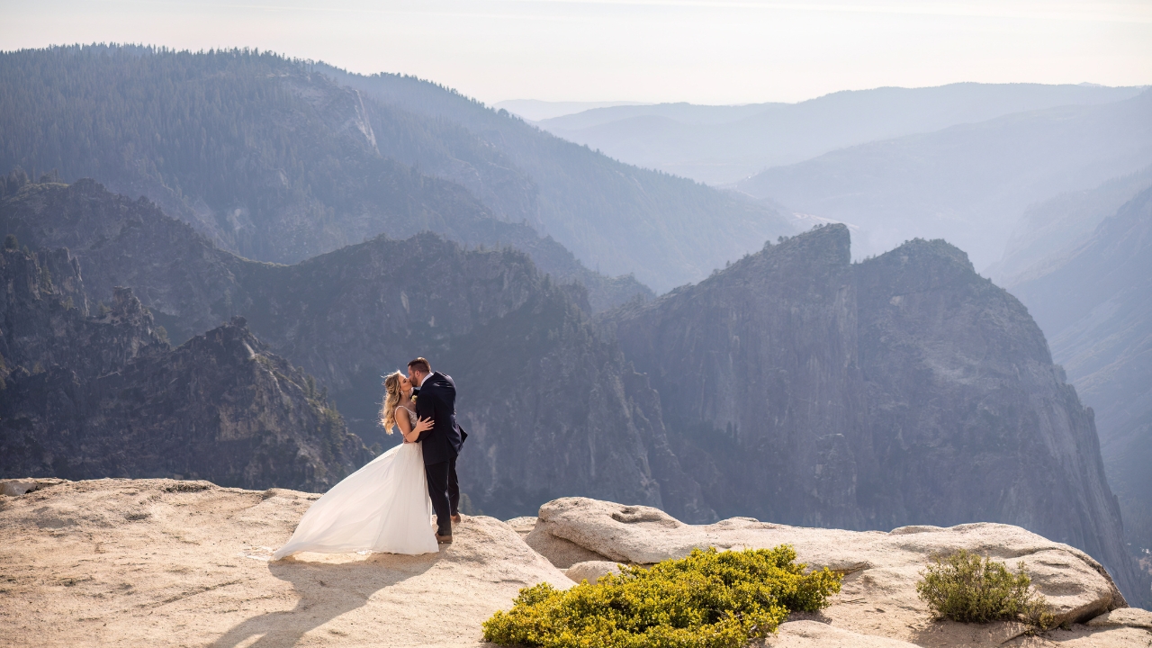 photo of bride and groom kissing at the edge of Taft Point