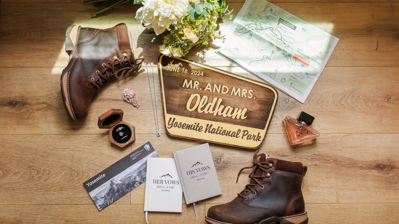 photo of wedding details for Yosemite elopement with park map, bouquet, hiking boots, perfume, vow book, and rings